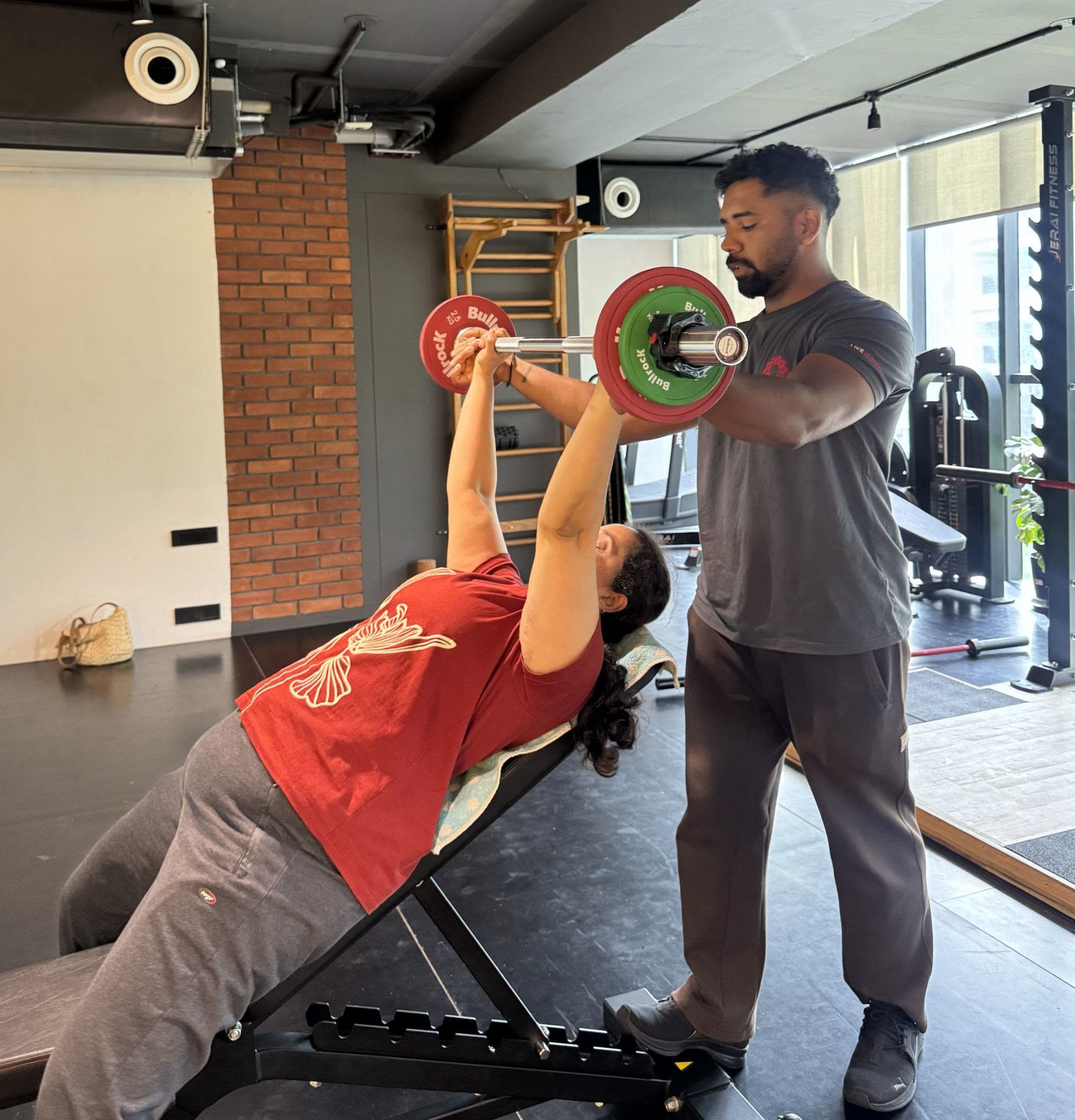 Founder Niranjan Dhuri coaching a client through an incline bench press